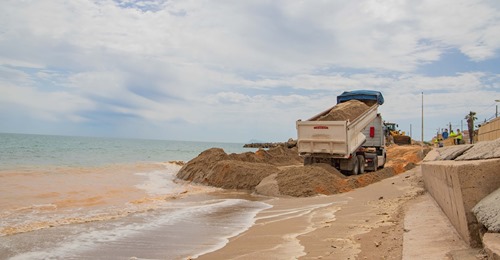 Un camión descargando la arena en la playa de Cullera